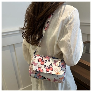 On-body view of a white crossbody bag with vibrant colorful butterfly patterns