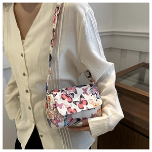 Side view of white crossbody bag with colorful butterfly prints on a model