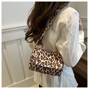 Detail of trendy leopard print crossbody bag with wide shoulder strap worn by model