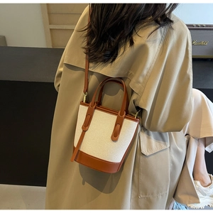 Canvas bucket bag with leather trim shown on model with vintage style decor