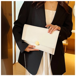 Borsa a tracolla a busta bianca minimalista con catena dorata indossata da modella