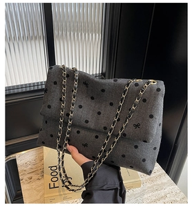 Detail of grey polka dot tweed tote bag with gold chain strap and bow accents