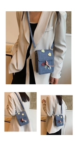 Detail view of light blue denim crossbody bag with colorful heart appliques and drawstrings
