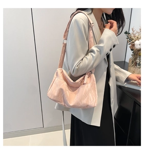 Detailed view of pink pleated nylon crossbody bag with woven zipper and adjustable strap