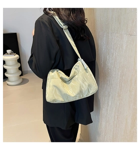 Detail of pistachio green tote bag with pleated texture and adjustable wide shoulder strap
