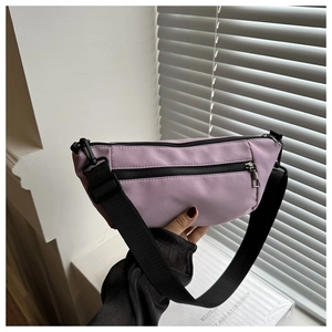 Detail of lavender crescent crossbody bag with black nylon strap and zipper pocket