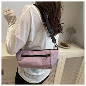 Detail of light purple crossbody bag featuring matte nylon fabric and adjustable strap