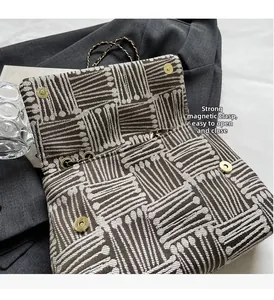 Detail of vintage geometric canvas bag showing magnetic buckle and gold chain strap