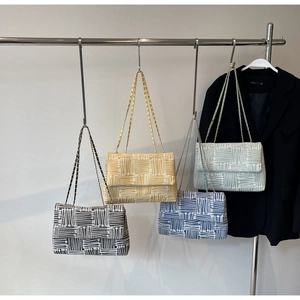Detail view of woven tote bags in four colors with elegant metal chain shoulder straps