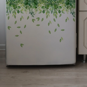 Watercolor green leaf wall stickers applied to a white cabinet above light wood flooring