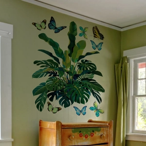 Détail de feuilles tropicales de monstera et stickers muraux papillons colorés de salon