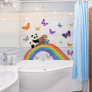Dettaglio di adesivi murali con arcobaleno, bradipo e panda su piastrelle blu