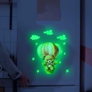 Luminous wall sticker showing cartoon bear on hot air balloon with stars in green glow