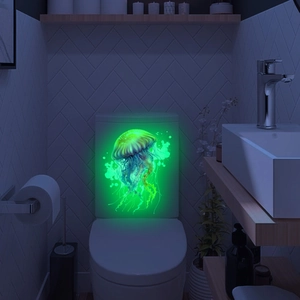 Glow-in-the-dark green jellyfish wall sticker detail on white ceramic toilet tank surface