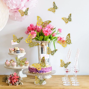 Detailed view of hollow gold glitter butterflies decorating a festive layered cake set