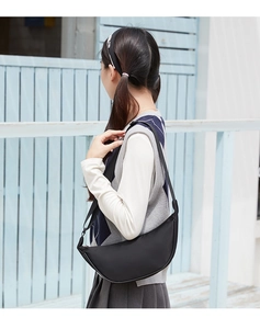 Detail view of the black half-moon shoulder bag with adjustable strap and silver buckle
