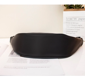 Detail view of the black nylon shoulder bag showing curved bottom and smooth stitching