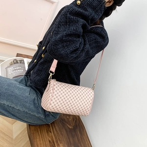 Pink floral print cylinder shoulder bag with wide strap worn with casual outfit