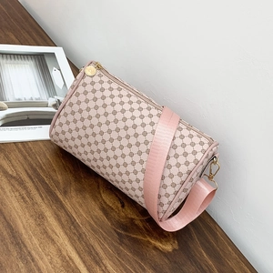 Pink cylinder pillow bag with floral geometric print and wide nylon strap on wooden desk
