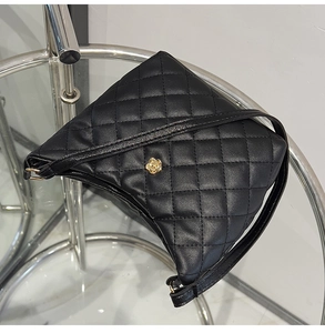 Dettaglio borsa a tracolla trapuntata nera con elegante fibbia a fiore in metallo oro