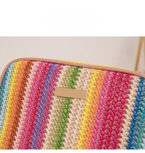 Close-up of colorful striped straw woven bag with gold metal plate and leather trim