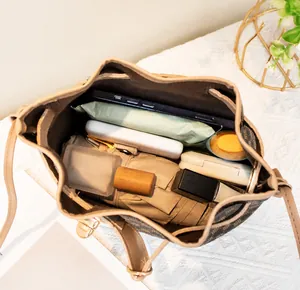 Intérieur spacieux du sac seau contenant téléphone, cosmétiques et accessoires