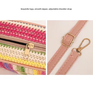 Detail of smooth metal zipper and adjustable pink leather strap on striped straw bag