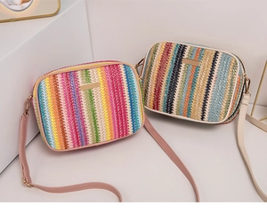 Detailed close-up of colorful striped woven straw bags with chic metal logo plates