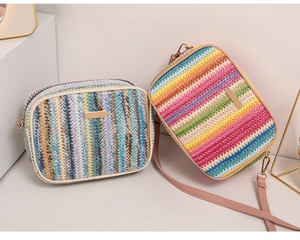 Detail of colorful striped straw woven crossbody bags with golden metal hardware and strap
