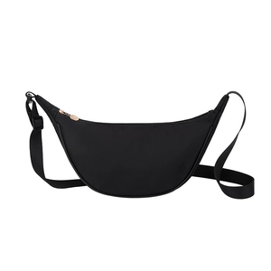 Minimalist black crescent crossbody bag in premium nylon with adjustable strap and zip top