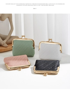 Group display of mini shell coin purses in green, white, pink, and black textured fabric