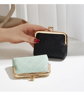 Detail of woven shell coin purses in black and mint green with gold clasp closures