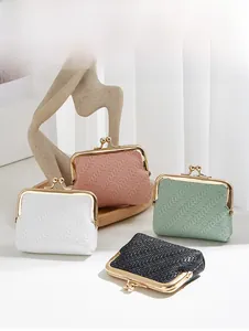 Detailed view of woven texture coin purses in pink, white, green and black with gold clasps
