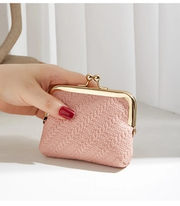 Detail of pink woven texture coin purse with vintage gold metal clasp in hand