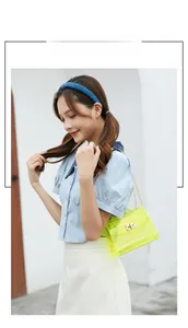 Fluorescent yellow jelly bag with gold chain strap shown in a stylish outdoor setting