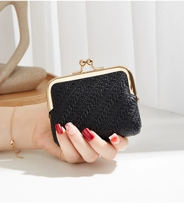 Detail of black woven texture coin purse with vintage gold ball clasp held by a model