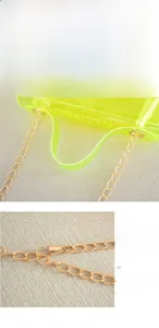 Detail of neon yellow PVC bag featuring adjustable gold-plated chain strap and buckle