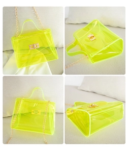 Detail view of neon yellow transparent PVC jelly bag with gold chain and metal buckle