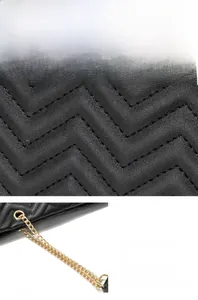 Detail of black tote bag featuring V-shaped quilting and a gold chain strap