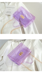 Detail of purple transparent jelly bag with gold metal twist lock and chain strap
