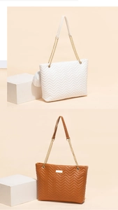 Detail of chevron quilted 2-piece tote set in white and brown with metal chain straps