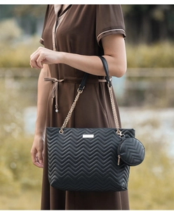 Detail of black wave quilted tote bag with gold chain strap and mini coin purse set