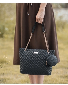 Detail of black wave quilted tote bag with gold chain strap and mini round coin purse charm