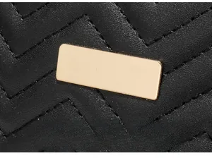 Detail view of gold rectangular hardware on black quilted faux leather tote bag