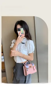 Pink checkered crossbody mini bag with silk scarf handle detail on model