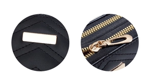 Detail of black quilted leather wallet with golden zippers and V-shaped stitching