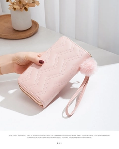 Pink quilted leather clutch with double zipper, wrist strap and pompom accessory
