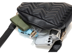 Detail showing the internal storage capacity of the quilted crossbody camera bag