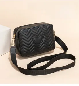 Detail of V-quilted black crossbody bag with heart embroidery and nylon strap