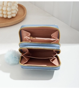 Detail der hellblauen kurzen Brieftasche mit Doppelreißverschluss und Plüsch-Anhänger